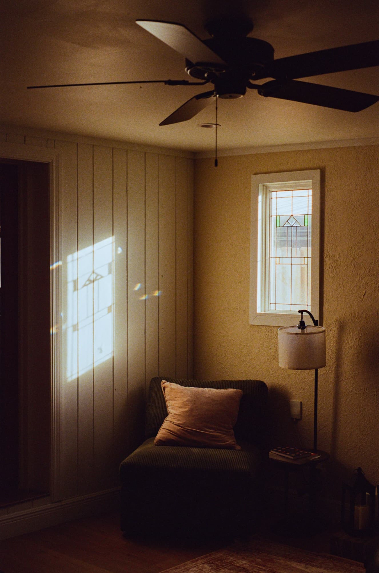 Film frame on Kodak Portra 800 — window light falling across an armchair in a quiet room